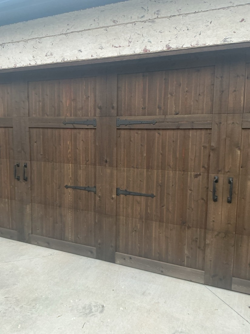 Rustic wooden two-car garage door with repaired spring system