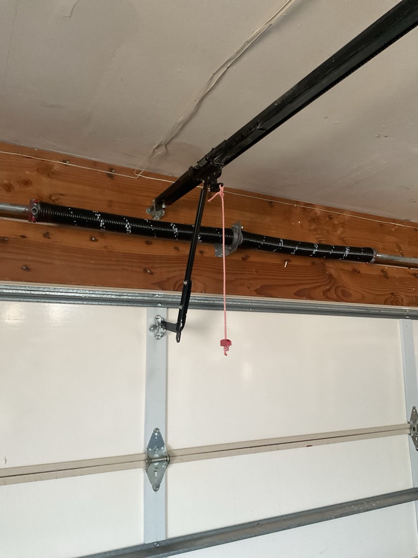 Garage door opener, torsion bar, and spring assembly mounted to wooden header
