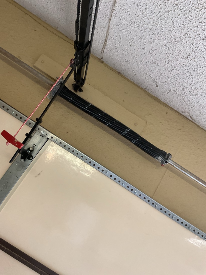 New garage door torsion spring and hardware installed on door frame