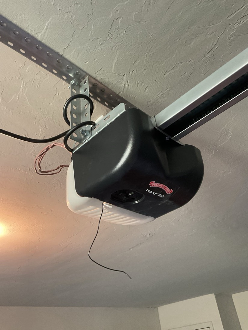 Black Genie garage door opener mounted on garage ceiling