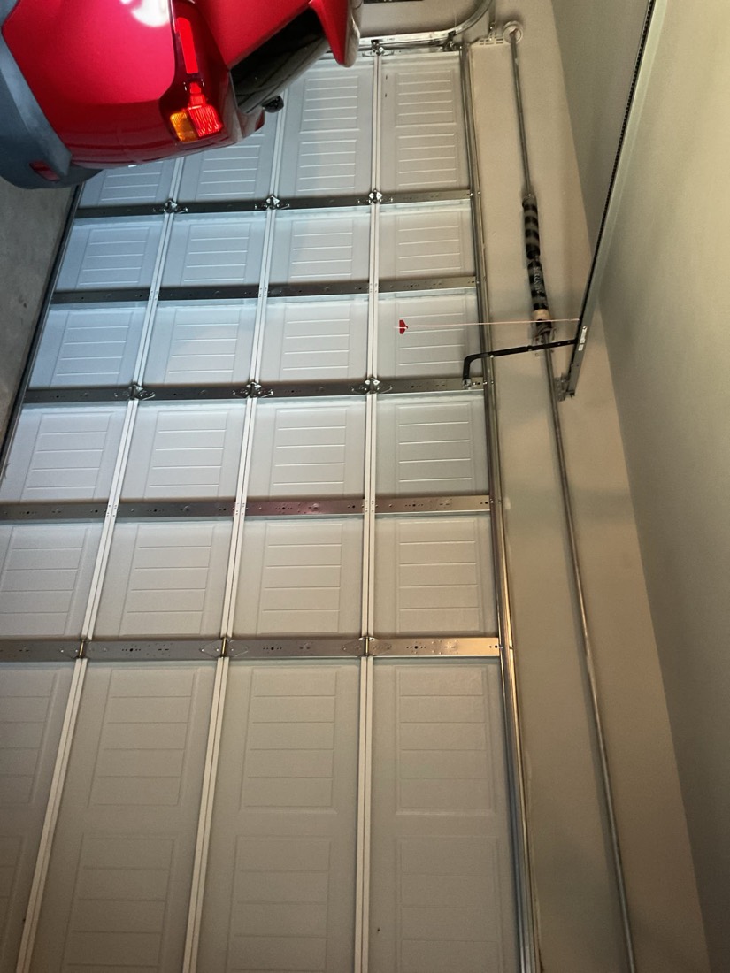 White multi-panel garage door fully closed after spring repair