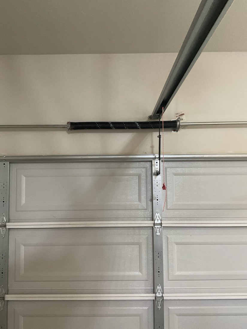 Garage door with new torsion spring and pulley system installed